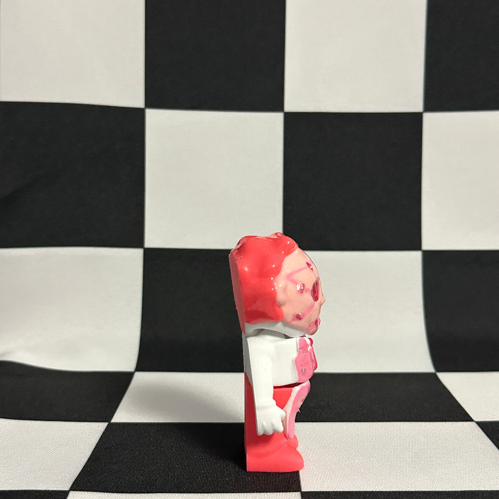 Toy figure with a red and white design on a black and white checkered background