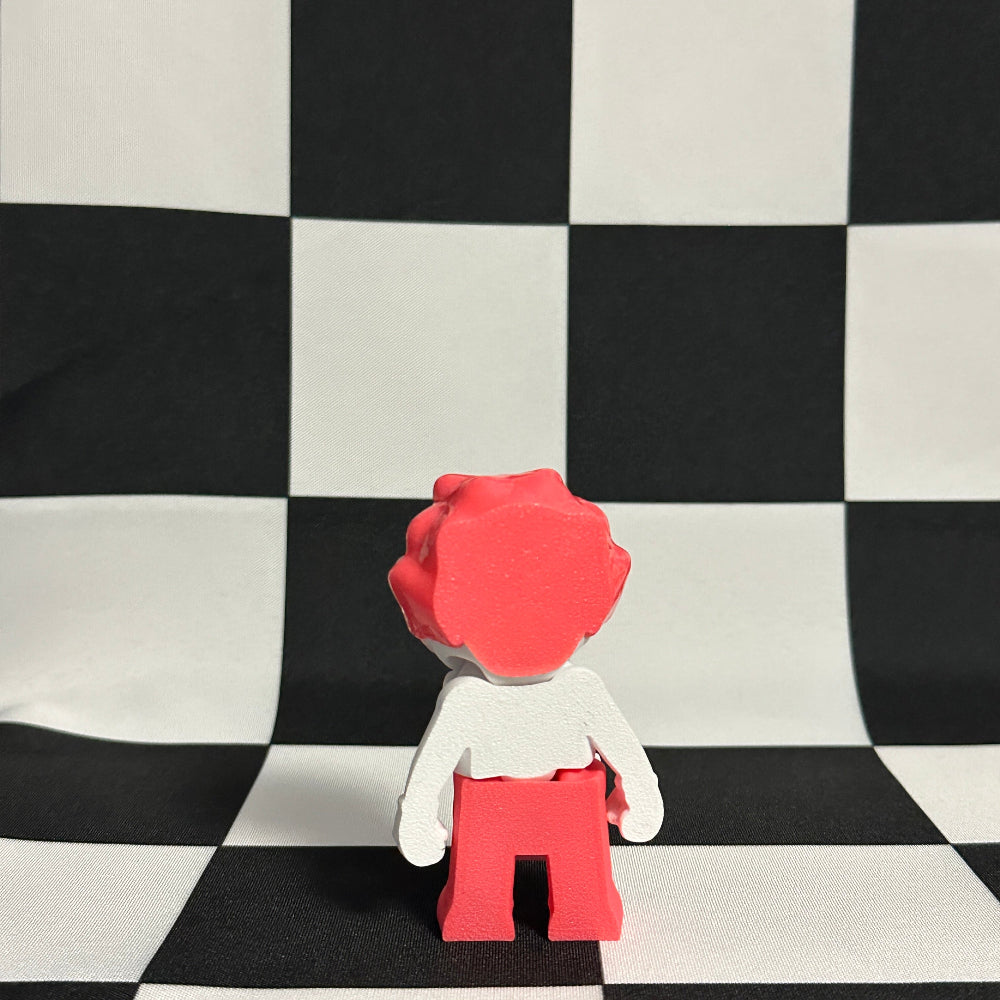 Small figure with red hair and pants standing on a black and white checkered surface