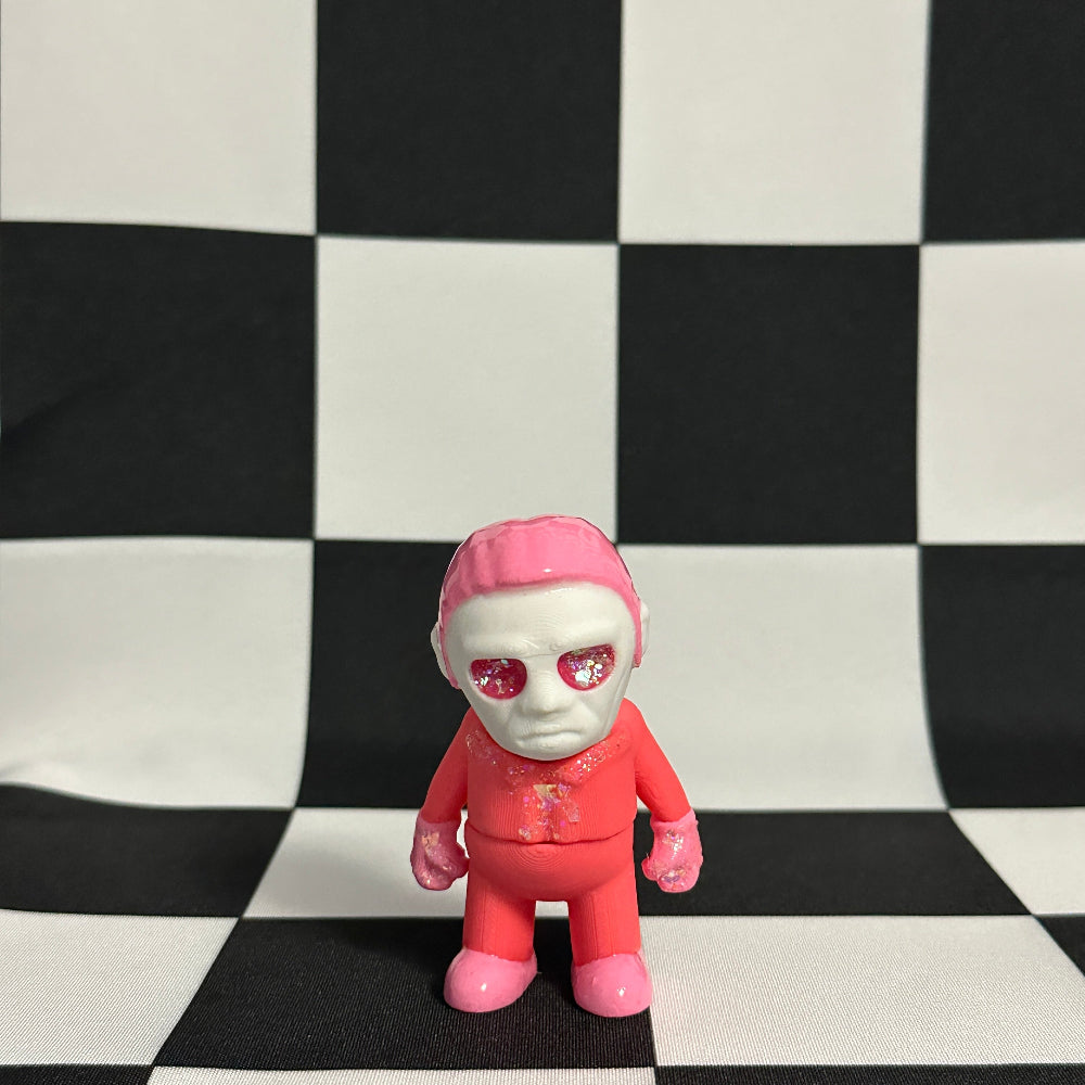Toy figure with pink head and pants on a black and white checkered background