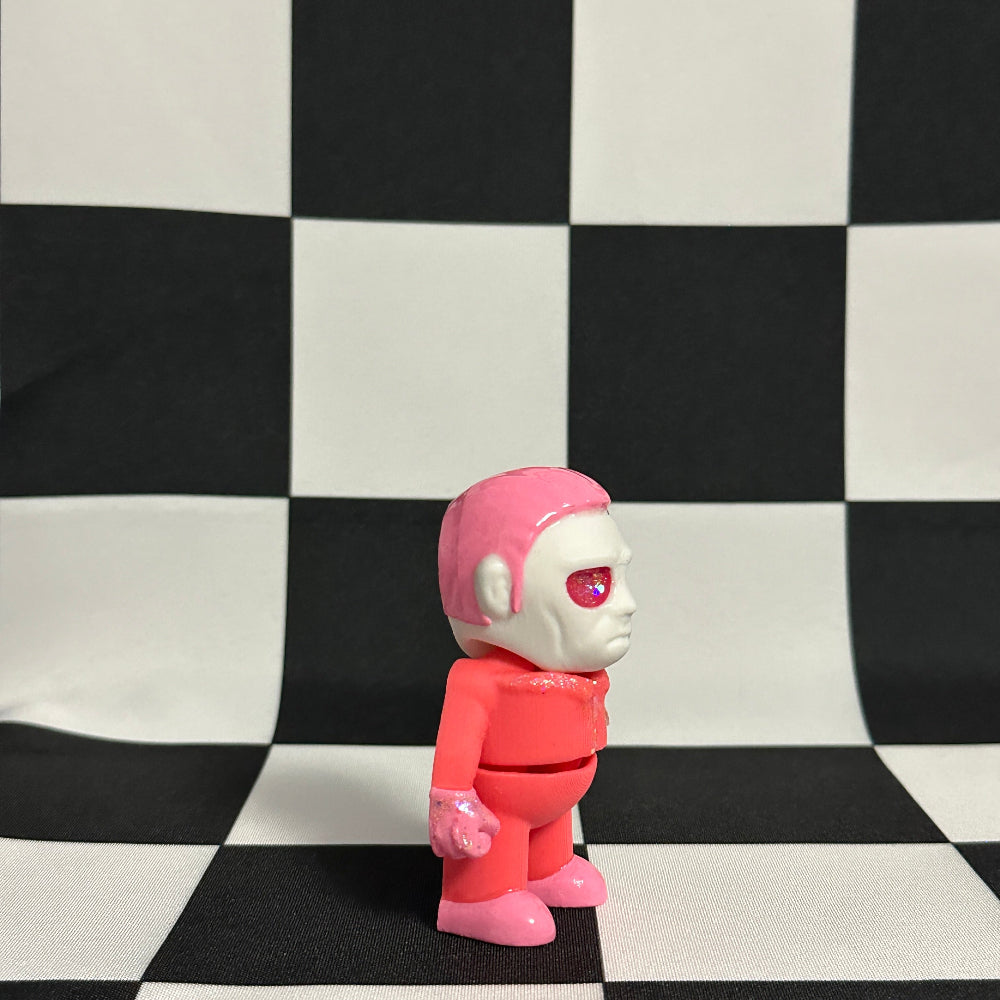 Pink and white robot toy on a black and white checkered background