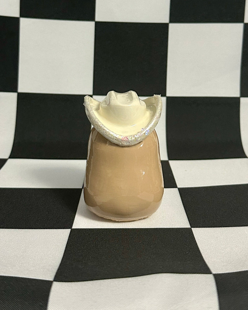 Beige capybara with white fur trim on a black and white checkered background