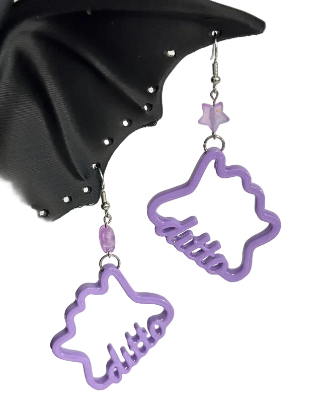 purple ditto earrings hanging from a black cat earring holder